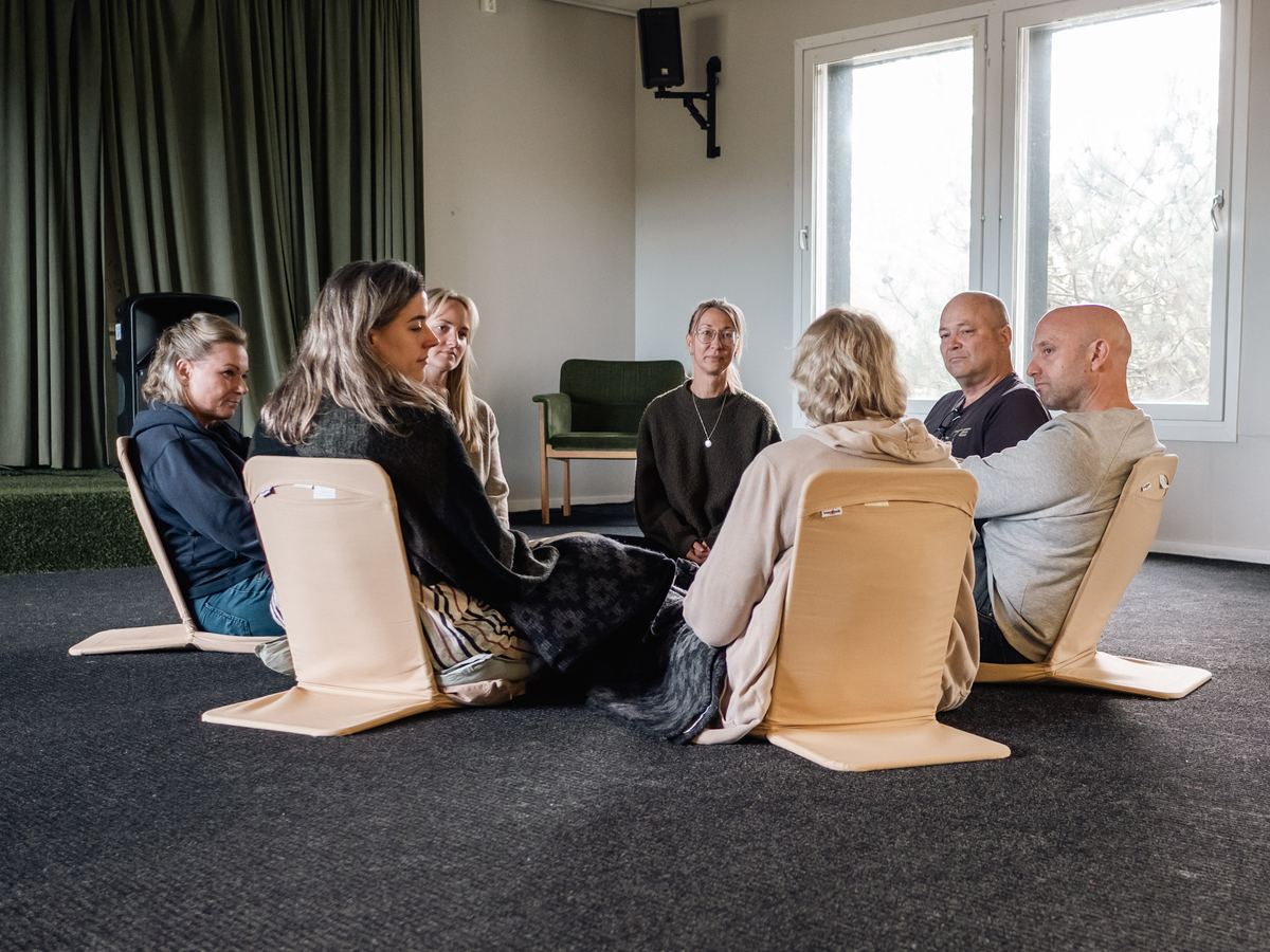 Deltagare sitter i en ring i kursrummet och samtalar.